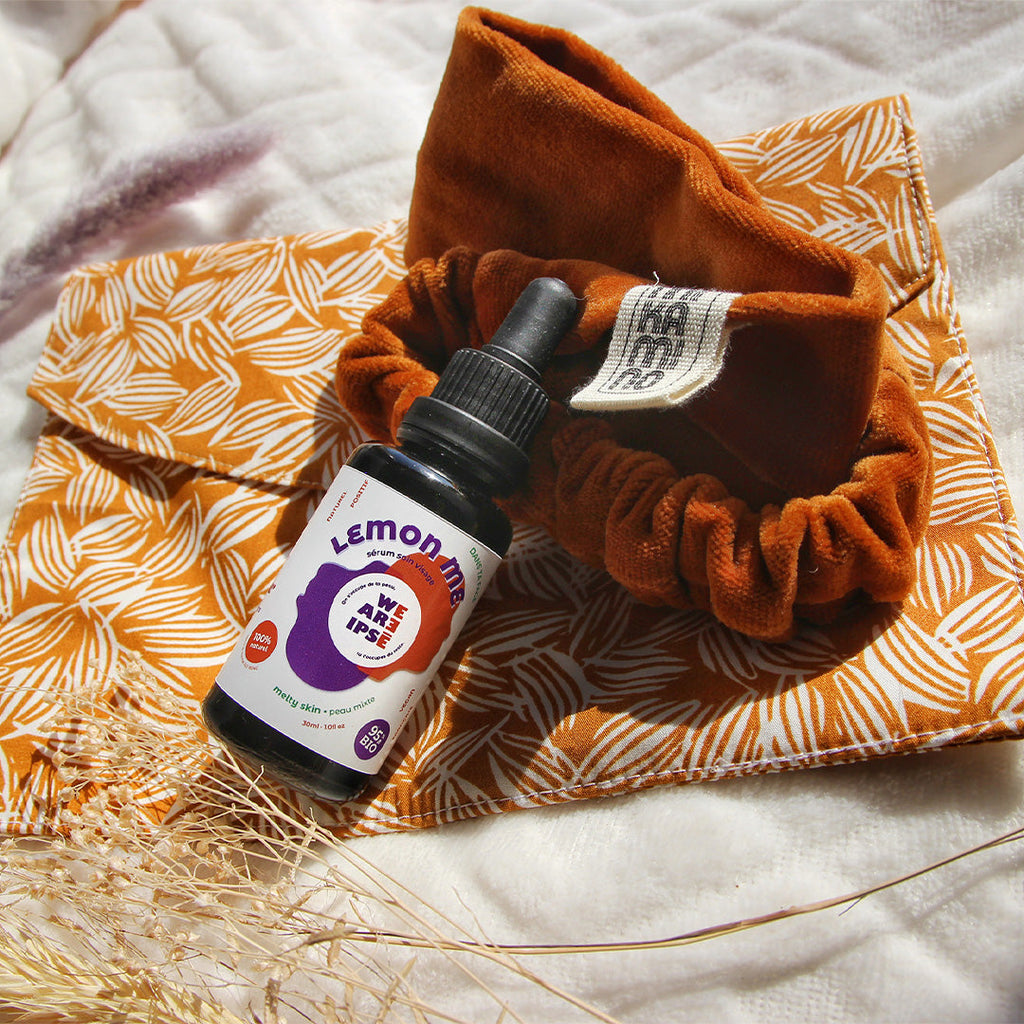 Photo de bandeau de soin mikamino couleur crinière de lion serum huile de jojoba et trousse de toilette terracotta sur un fond un tissu blanc