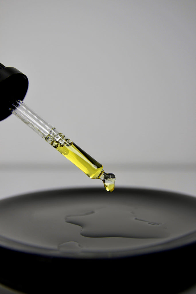 dans la pipette, nous pouvons trouver le sérum peau mixte qui n'a pas d'effet gras, coulant dans une assiette noire. 